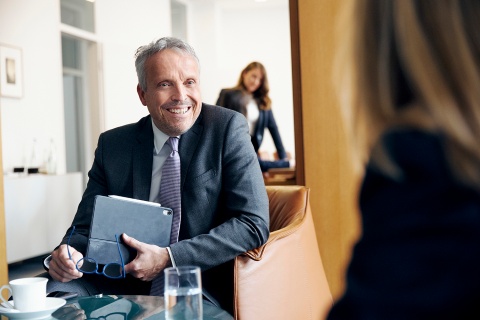 Klaus Sojer in einer klassischen Beratungssituation in einem Büro der Bankan einem Tisch